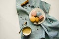 A cup of hot cappuccino with cinnamon and multi-colored cake macaroons