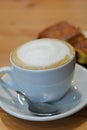 Cup Of Hot Cappuccino And Dessert On The Wooden Table