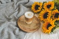 Cup with hot cappuccino, gray pastel woolen blanket, sunflowers, bedroom Royalty Free Stock Photo