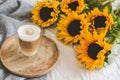 Cup with hot cappuccino, gray pastel woolen blanket, sunflowers, bedroom Royalty Free Stock Photo