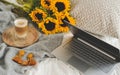 Cup with hot cappuccino, gray pastel woolen blanket, sunflowers, bedroom Royalty Free Stock Photo