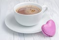 A cup of hot chocolate with a heart-shaped macaron