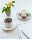 Cup of hot chocolate with macarons flowers and notepad