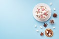 Cup of hot chocolate with marshmallow cocoa powder and caramel nuts, oranges on pastel blue background with copy space. Christmas