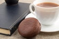 Cup of hot chocolate, old book and biscuit on old tablecloth Royalty Free Stock Photo