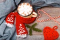 Cup of hot cocoa or chocolate with red scarf, handmade scarf and Christmas candy cane on wooden table, copy space Royalty Free Stock Photo