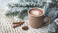 Cup of hot cocoa or hot chocolate on knitted background with fir tree and snow effect, traditional beverage for winter time Royalty Free Stock Photo