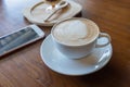 Cup of hot coffee ad smartphone put on old wooden table background