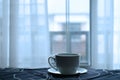 A cup of hot coffee in bed with nice view and white curtain from window. Royalty Free Stock Photo