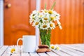 Cup of hot coffee, biscuits and a bouquet of chamomiles. Royalty Free Stock Photo