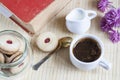 Cup of hot coffee with books, milk and flowers on wooden table Royalty Free Stock Photo