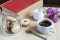 Cup of hot coffee with books, milk and flowers on wooden table Royalty Free Stock Photo