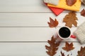 Cup of hot coffee, books, sweater and autumn leaves on white wooden table, flat lay. Space for text Royalty Free Stock Photo