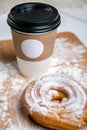 Cup of hot coffee with choux cake on the wooden table on white background. Fast breakfast. French cuisine. Good morning