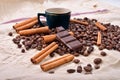 Cup of hot coffee with cinnamon sticks, bitten bar of chocolate Royalty Free Stock Photo