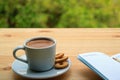 A Cup of Hot Coffee with Cookies and Lined Note Papers on the Wooden Table of Outdoor Seating Royalty Free Stock Photo