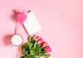 The cup of hot coffee, empty notepad with funny pen and bouquet of fresh roses on soft pink background Royalty Free Stock Photo