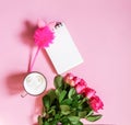 The cup of hot coffee, empty notepad with funny pen and bouquet of fresh roses on soft pink background Royalty Free Stock Photo