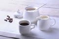 Cup of hot coffee espresso, coffee beans, jug of milk, and bowl with sugar on white background for copy space. Coffee Royalty Free Stock Photo