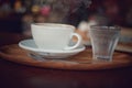 A cup of hot coffee with a glass of cold water on the tray, ready for serve. Royalty Free Stock Photo