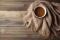 Cup of hot coffee with milk on brown wooden background. Warm beige scarf creates a cozy atmosphere. Royalty Free Stock Photo