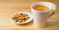 Cup of Hot Coffee with a Plate of Biscuits on Wooden Table Royalty Free Stock Photo