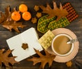 Cup of hot coffee White chocolate cookies tangerines with oak leaves with mitten notebook on wooden background Royalty Free Stock Photo
