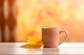 A cup of hot drink tea or coffee anf golden maple autumn leaf on the wooden table. Fall season background with copy Royalty Free Stock Photo