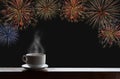 Cup of hot drinks on wooden desk with new year celebrate fireworks on night sky