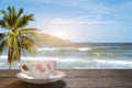 A cup of hot espresso coffee mugs placed on a wooden floor on sea view with sunlight background,coffee morning