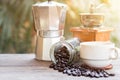 A cup of hot espresso coffee mugs and roasted coffee beans with moka pot placed on wooden floor background,coffee morning, Royalty Free Stock Photo