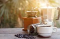 A cup of hot espresso coffee mugs and roasted coffee beans with moka pot placed on wooden floor background,coffee morning, Royalty Free Stock Photo