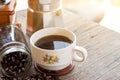 A cup of hot espresso coffee mugs and roasted coffee beans with moka pot placed on wooden floor background,coffee morning, Royalty Free Stock Photo