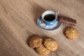 A cup of hot fragrant black coffee in a saucer with cookies and a chocolate bar Royalty Free Stock Photo