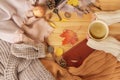 Cup of hot fragrant coffee in the hands of a woman, autumn leaves, an apple, cozy scarves and knitted sweaters, an e-book, flat, Royalty Free Stock Photo