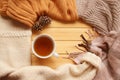 Cup of hot fragrant tea on a wooden background, autumn leaves, apple, cozy scarves and knitted sweaters, flat, concept hugge, Royalty Free Stock Photo