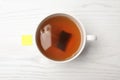 Cup of hot fresh tea with bag on wooden background Royalty Free Stock Photo