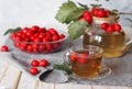 A cup of hot hawthorn tea made from freshly picked berries, herbal medicine for heart health on rustic wooden background Royalty Free Stock Photo