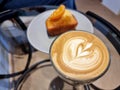A cup of hot latte art coffee with orange cake Royalty Free Stock Photo