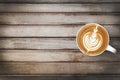 Cup of hot latte coffee is on top of wood table. Top view with copy space, flat lay Royalty Free Stock Photo