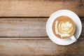 Cup of hot latte coffee us on top of wood table. Top view with copy space, flat lay Royalty Free Stock Photo