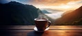 A cup of hot morning coffee with steam on a wooden table against a background of sunrise scene in the mountains. Royalty Free Stock Photo