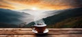 A cup of hot morning coffee with steam on a wooden table against a background of sunrise scene in the mountains. Royalty Free Stock Photo