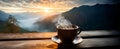 A cup of hot morning coffee with steam on a wooden table against a background of sunrise scene in the mountains. Royalty Free Stock Photo