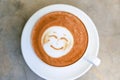 Cup of hot tasty cappucino with smile as art latte