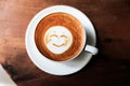 Cup of hot tasty cappucino with smile as art latte