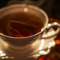 Cup of a hot tea in cafe. Anamorphic bokeh effect. Tilt-shift photo. Tasty aromatic tea in a lovely cup with a saucer