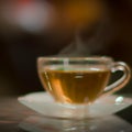 Cup of a hot tea in cafe. Anamorphic bokeh effect. Tilt-shift photo. Tasty aromatic tea in a lovely cup with a saucer