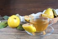 Cup of hot tea and fresh quince fruit on table