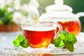 Cup with hot tea with mint and a thyme on a wooden table in a summer garden. Selective focus, Royalty Free Stock Photo